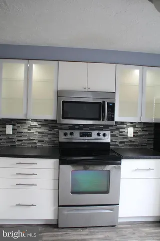 a kitchen with granite countertop a stove and a microwave
