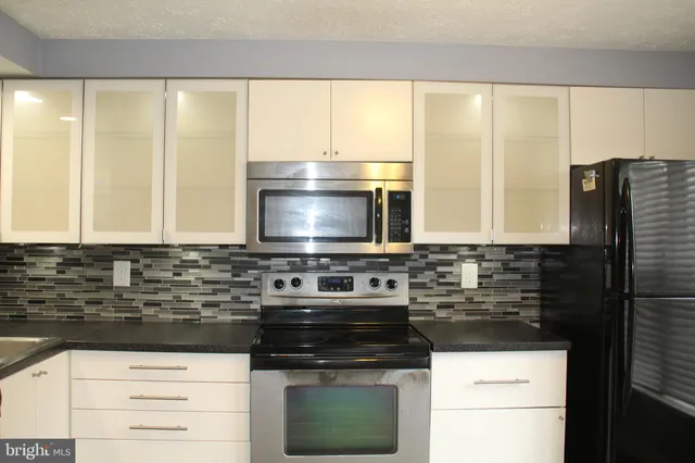 a kitchen with a sink a stove and a microwave