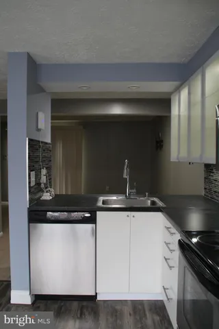 a kitchen with granite countertop a sink and a stove top oven