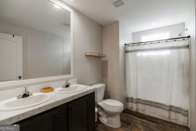 a bathroom with a sink a toilet and shower