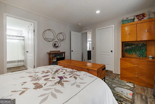 a bedroom with a bed and dresser with mirror