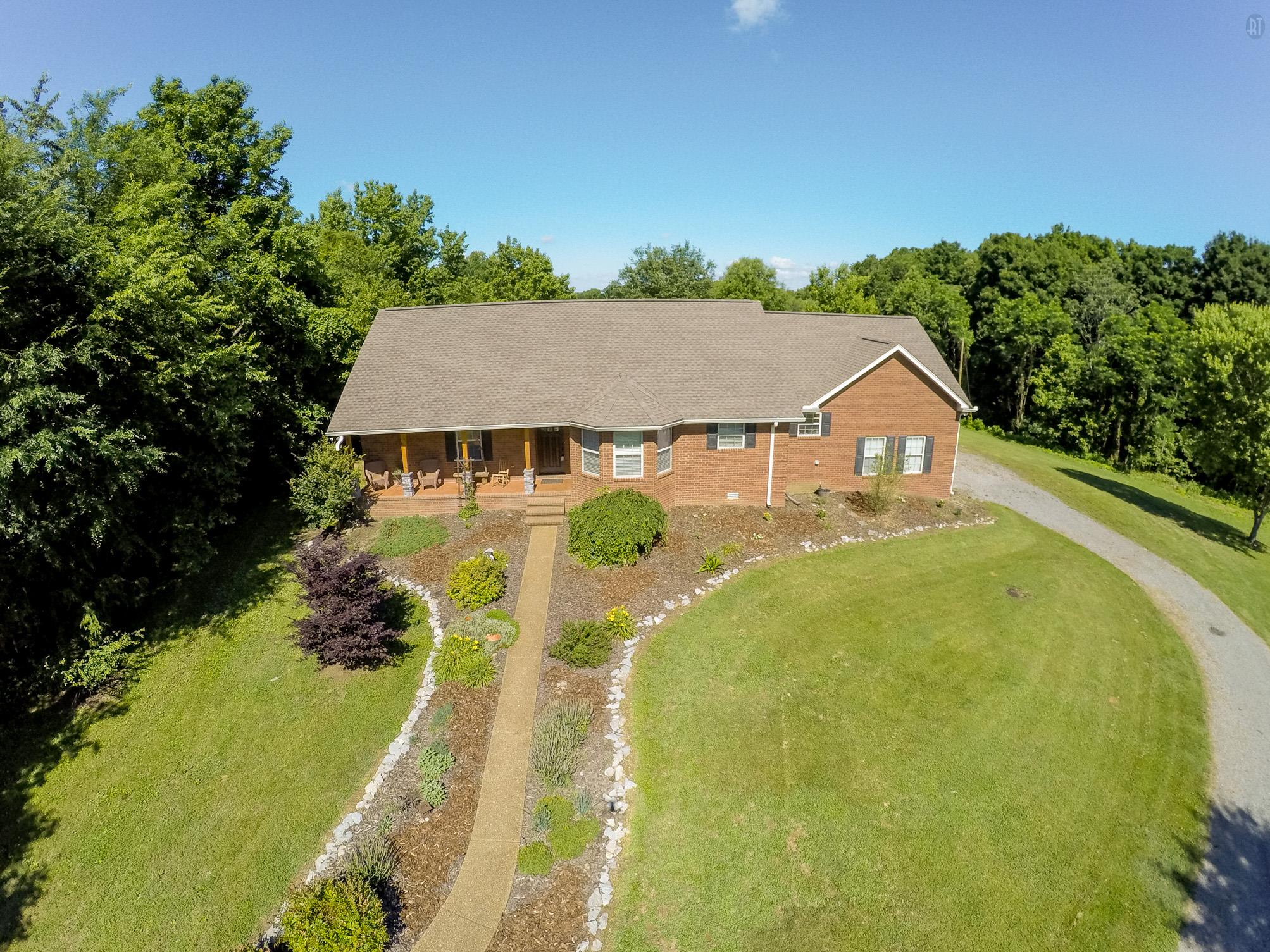 a aerial view of a house with swimming pool and large trees