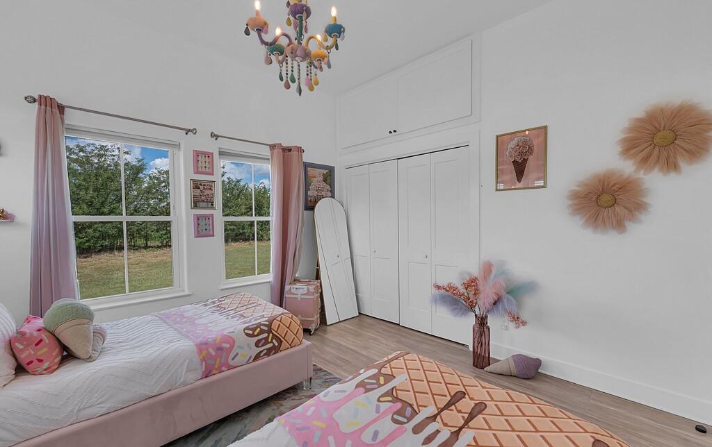 109 Springfield Lane Waco, TX 76705 - Photo 28 of 39 Bedroom with wood finished floors, a chandelier, and a closet
