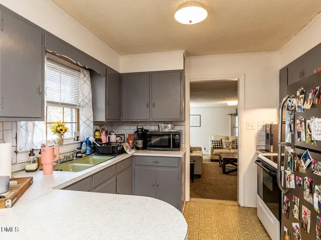 a view of a livingroom with furniture chandelier fan and windows