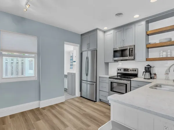 a kitchen with stainless steel appliances granite countertop a refrigerator stove and sink