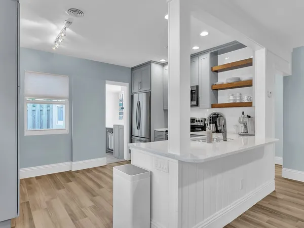 a kitchen with white cabinets and stainless steel appliances