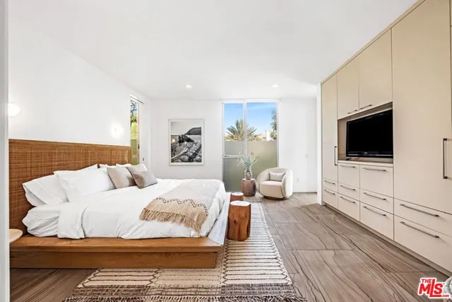 a bedroom with a large bed and a flat screen tv