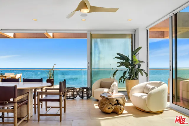 a dining room with furniture and a floor to ceiling window