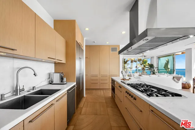a kitchen with sink a stove and cabinets