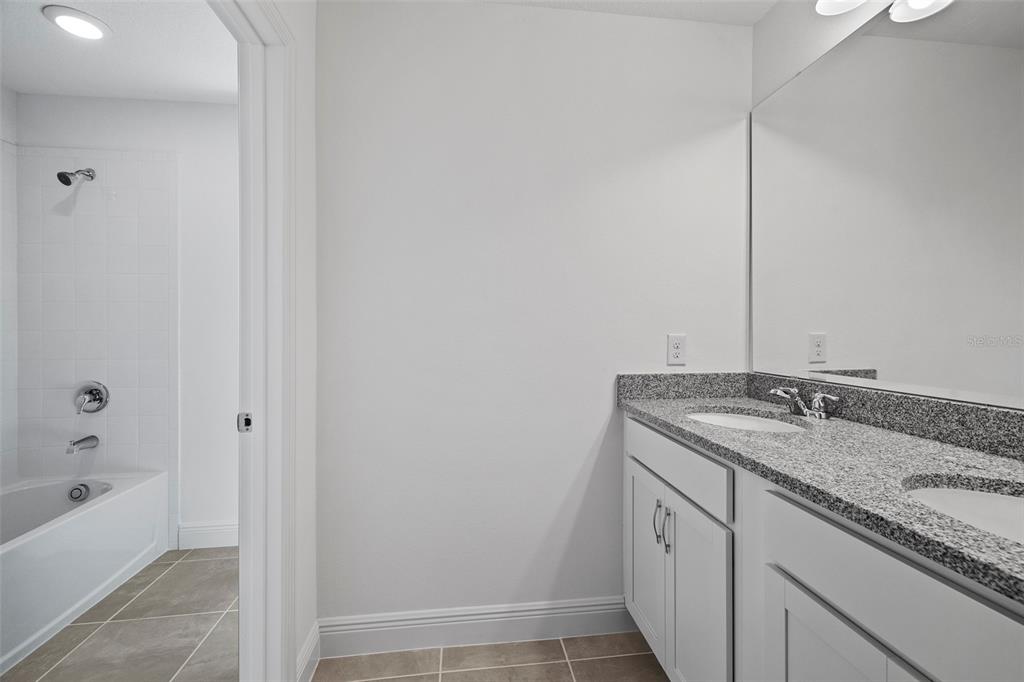 7120 Cherry Pasture Road Groveland, FL 34736 - Photo 11 of 23 a bathroom with a granite countertop sink and a mirror