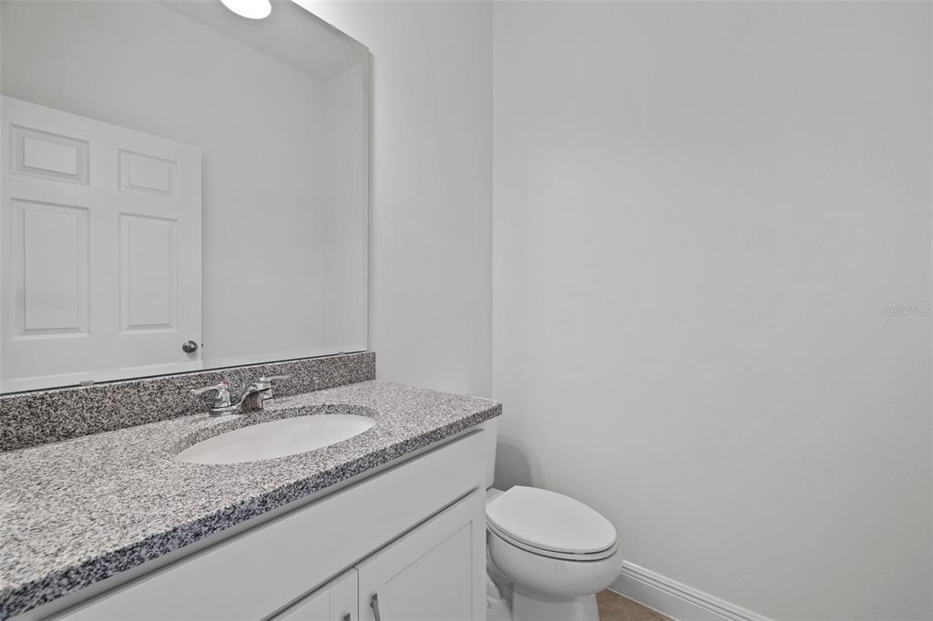 7120 Cherry Pasture Road Groveland, FL 34736 - Photo 5 of 23 a bathroom with a granite countertop sink a toilet and a mirror