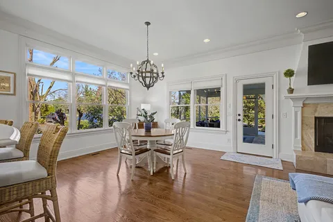 a view of a dining room with furniture a chandelier and wooden floor