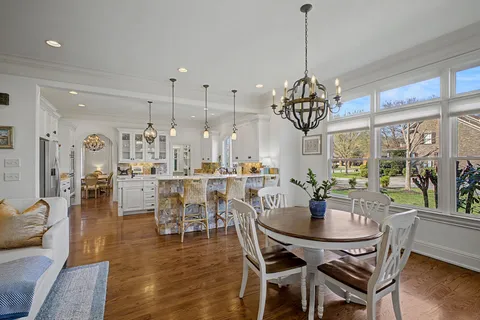 a dining room with furniture a chandelier and wooden floor