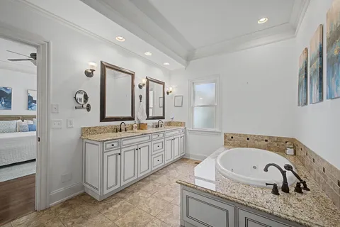 a bathroom with a granite countertop double vanity sink and mirror
