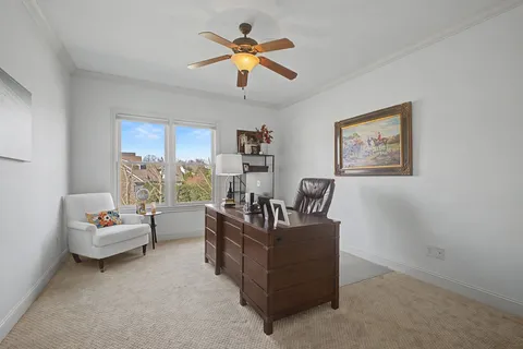 a view of a workspace with furniture and a window