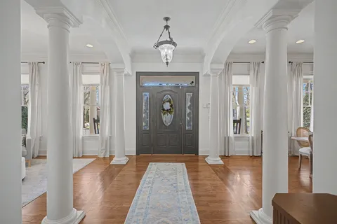 a hallway with wooden floor and windows