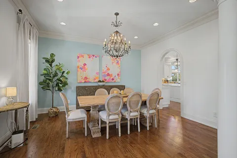 a view of a dining room with furniture wooden floor and chandelier