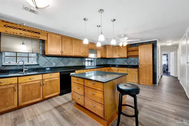 a kitchen with granite countertop a stove a sink and a refrigerator