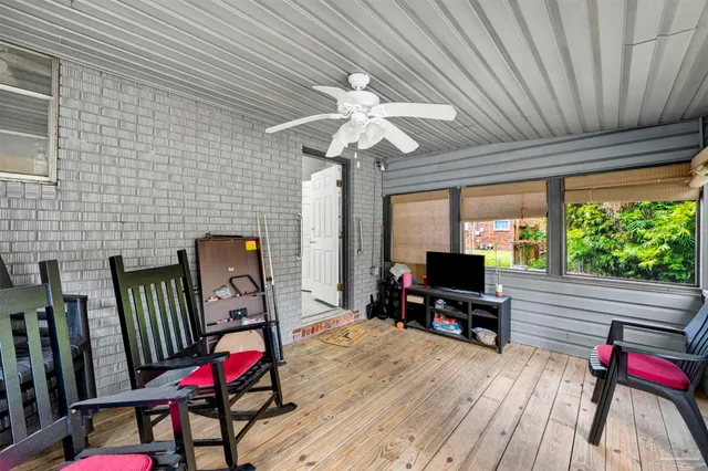 a living room with furniture a flat screen tv and a floor to ceiling window
