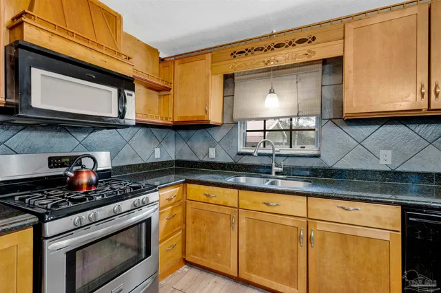 a kitchen with stainless steel appliances granite countertop a sink stove and microwave