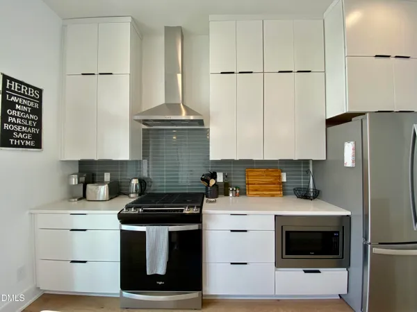 a kitchen that has a lot of cabinets a sink and appliances
