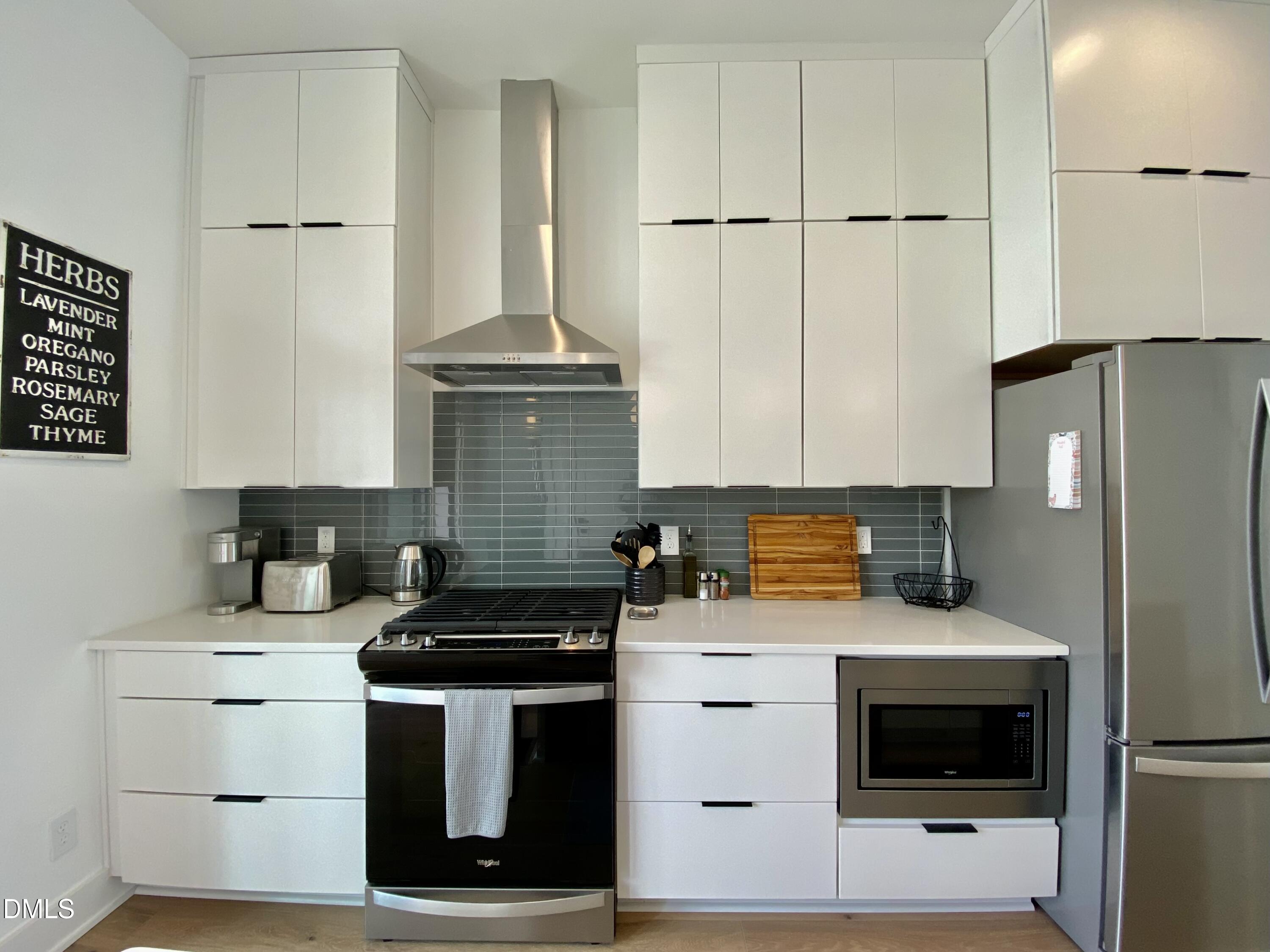 629 North Queen Street Durham, NC 27701 - Photo 12 of 58 a kitchen with stainless steel appliances a stove a sink and a refrigerator