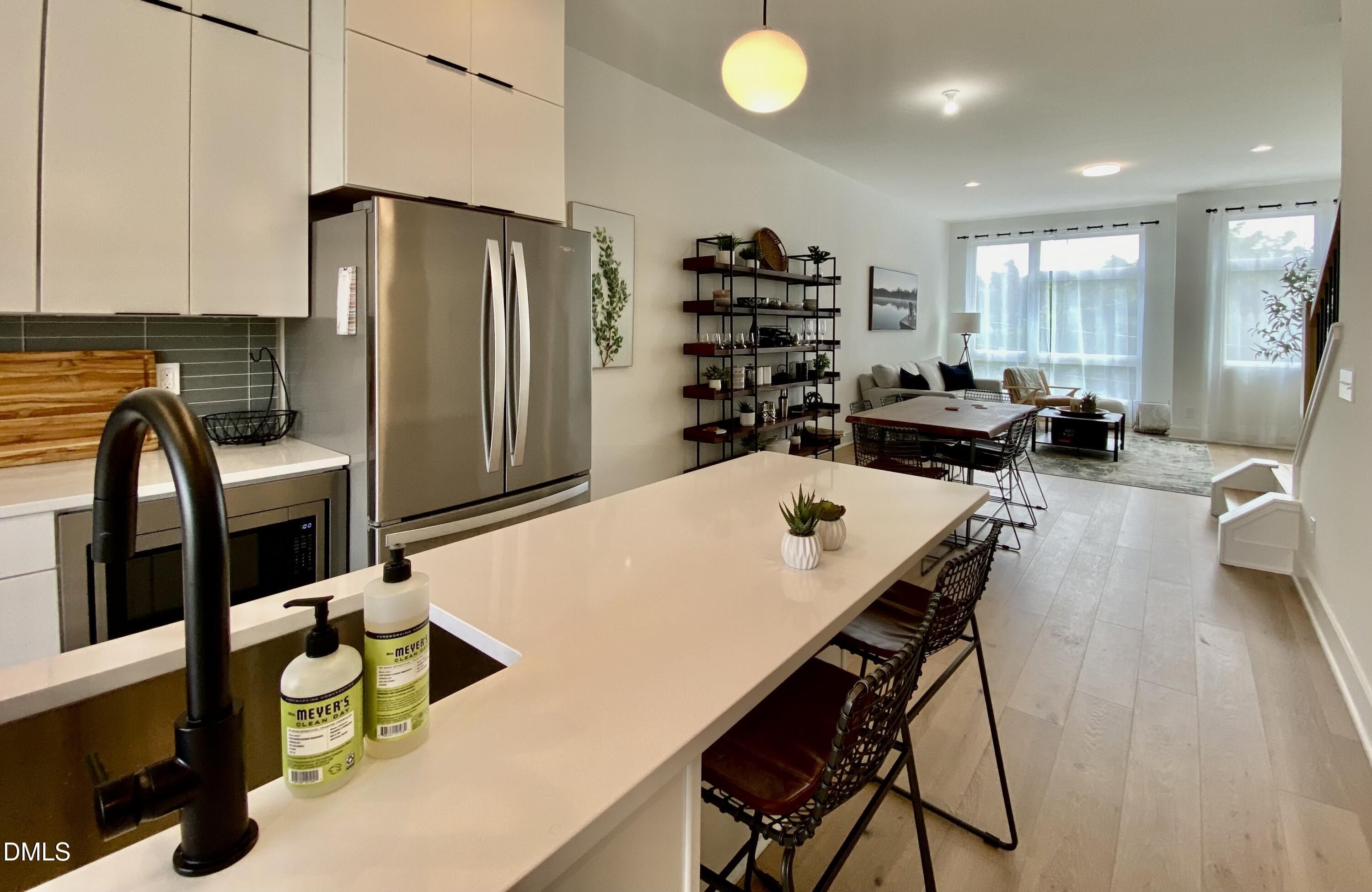 629 North Queen Street Durham, NC 27701 - Photo 18 of 58 a kitchen with stainless steel appliances wooden floor dining table and chairs
