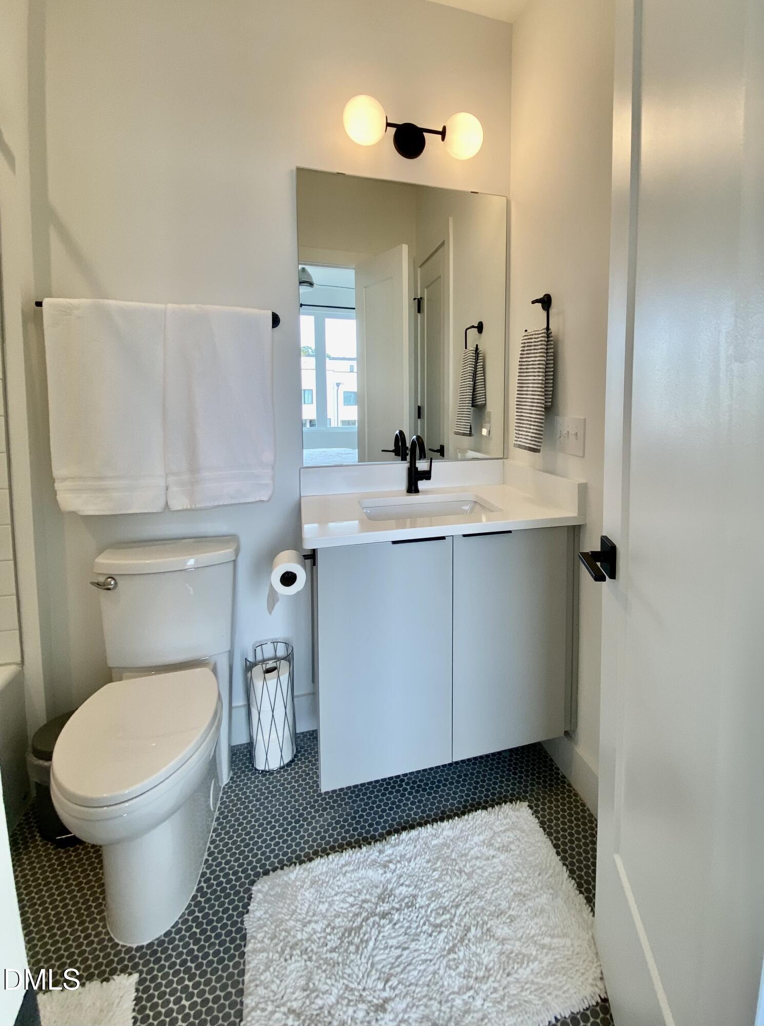 629 North Queen Street Durham, NC 27701 - Photo 33 of 58 a bathroom with a sink a toilet and mirror