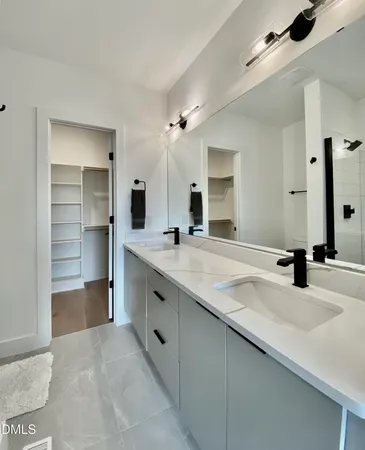 a en suite bathroom with a granite countertop sink and a mirror