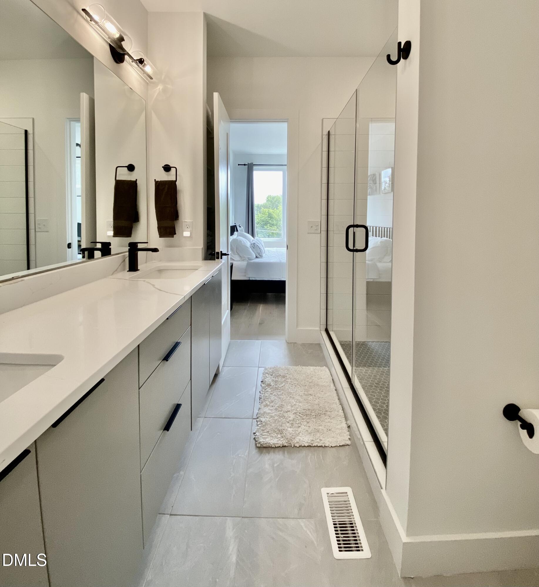 629 North Queen Street Durham, NC 27701 - Photo 45 of 58 a en suite bathroom with a granite countertop sink and a mirror