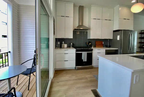 a kitchen that has a lot of cabinets in it and wooden floors