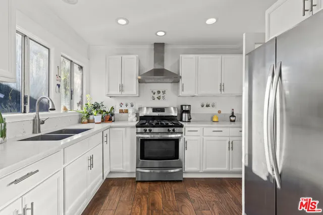 a kitchen with stainless steel appliances a stove a sink and a refrigerator
