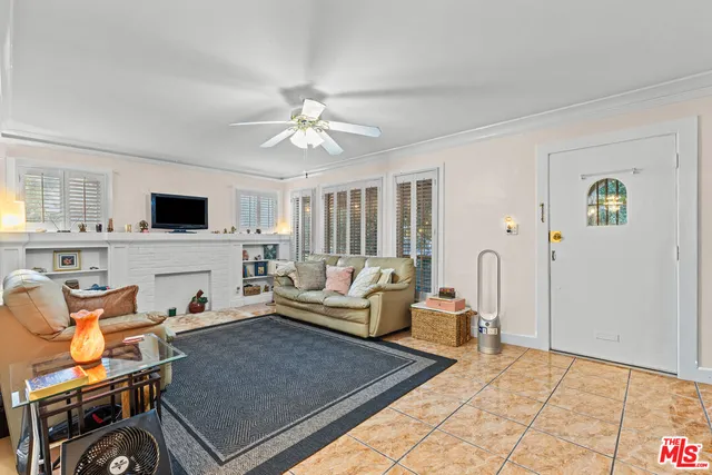 a living room with furniture a flat screen tv and kitchen view