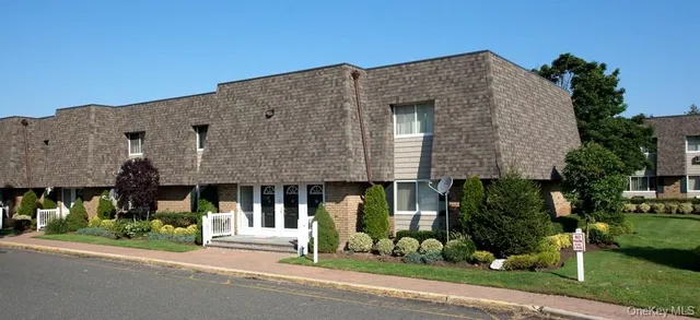 a front view of a house with garden and plants