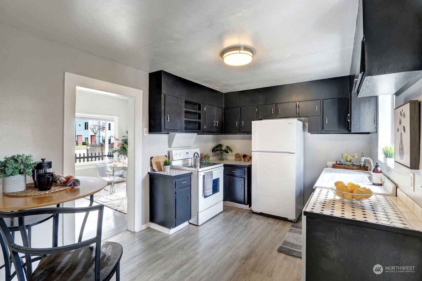 1718 Rockefeller Avenue Everett, WA 98201 - Photo 8 of 17 a kitchen with a refrigerator a stove top oven a sink dishwasher and white cabinets with wooden floor