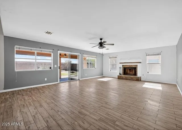 a view of empty room with wooden floor and fireplace