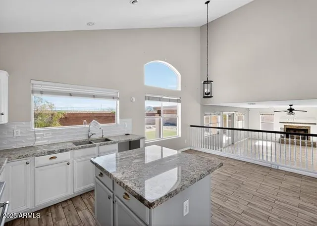 a kitchen with stainless steel appliances granite countertop a sink dishwasher and cabinets with wooden floor