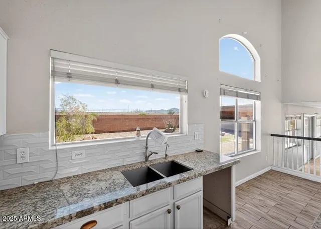 a kitchen with a granite countertop sink and cabinets