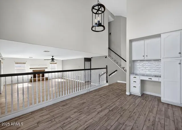 a view of a hallway with wooden floor and staircase