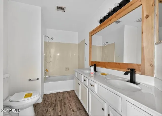 a bathroom with a sink a toilet a mirror and bathtub