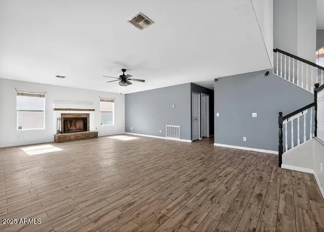 a view of empty room with fireplace and wooden floor