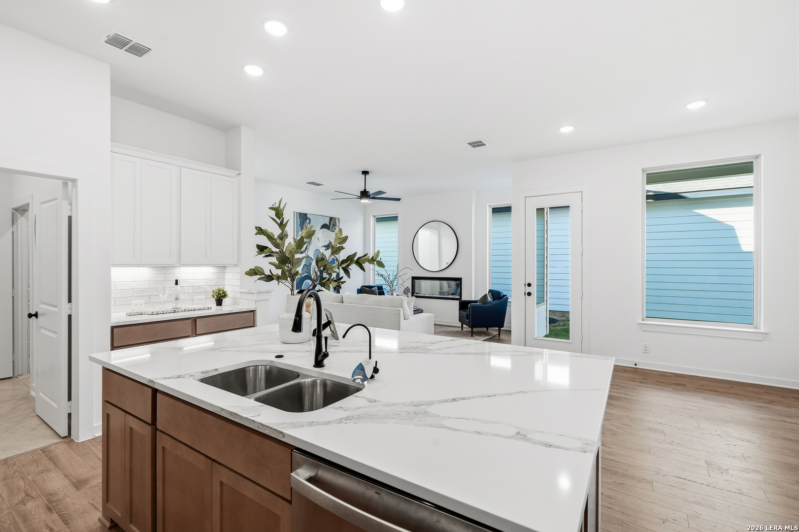 9421 Chatside Schertz, TX 78154 - Photo 27 of 48 a kitchen with a sink dishwasher and white cabinets with wooden floor