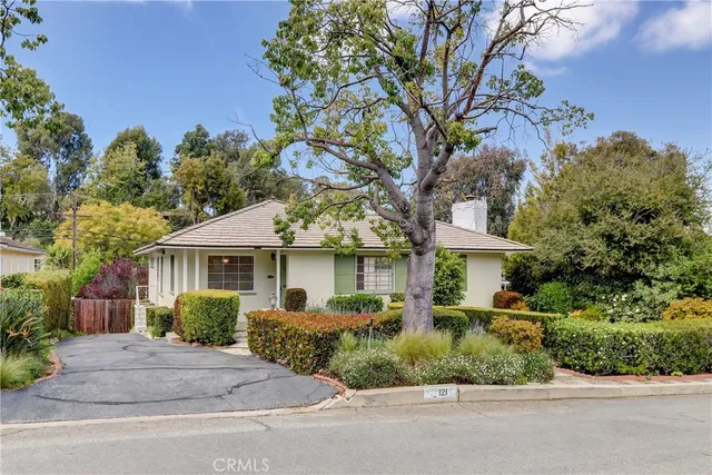 a front view of a house with a yard and potted plants