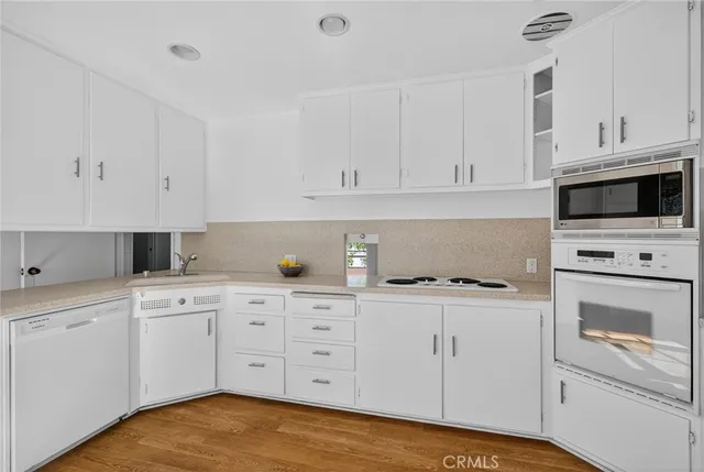 a kitchen with white cabinets and white appliances