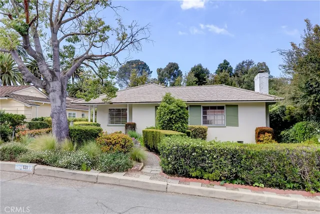 a front view of a house with a yard and potted plants