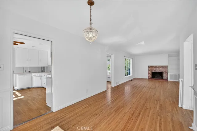 a view of a room with wooden floor and kitchen view