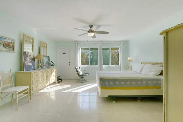 a spacious bedroom with a bed a table and chair