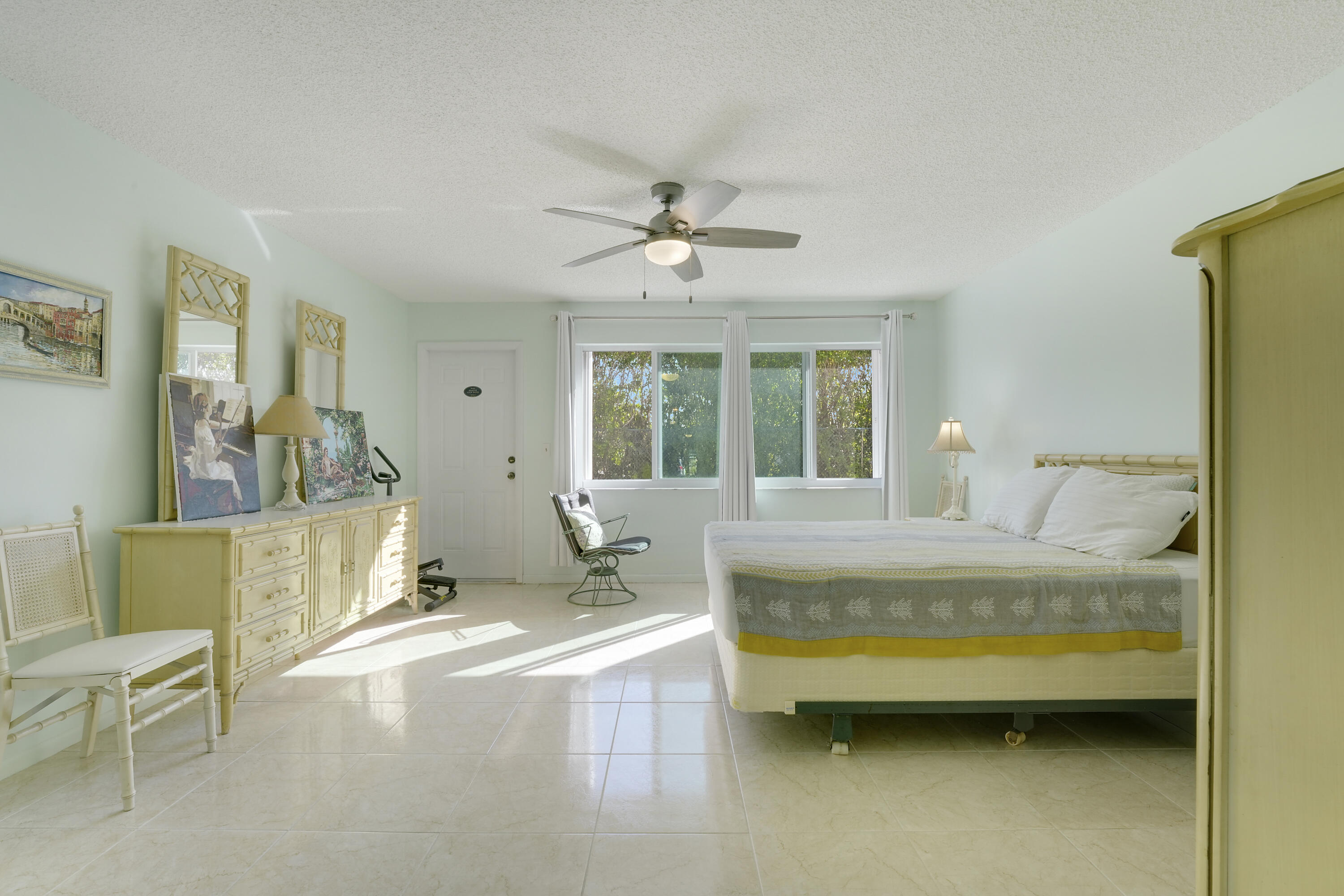 4515 Northwest 3rd Court, Unit C Delray Beach, FL 33445 - Photo 15 of 25 a spacious bedroom with a bed a table and chair