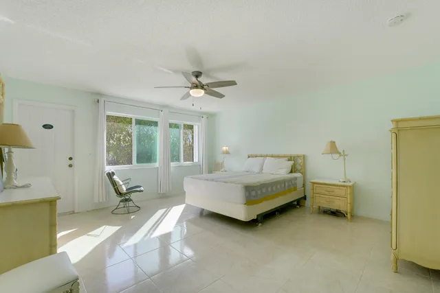 a spacious bedroom with a bed and a chandelier