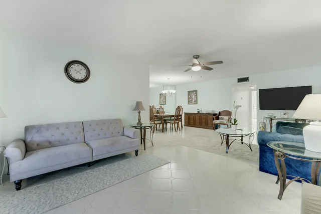 a living room with furniture a flat screen tv and a window
